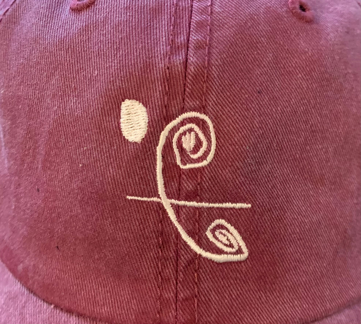Zoomed in detailed shot of First Bloom logo on hat
